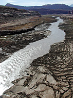 The Colorado River emerges from beneath the Hite bridge.